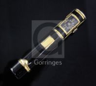 A gilded black enamel combination lipstick holder/watch, of cylindrical form, the swivelling