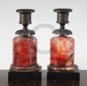A pair of Regency bronze and red fluorospar / Blue John mounted candlesticks, on black slate