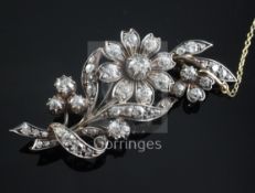A gold, silver and diamond set floral spray brooch, with safety chain, 56mm.