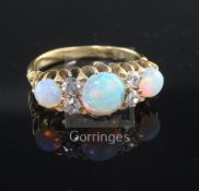 An Edwardian 18ct gold, white opal and diamond ring, set with three oval opals and four round cut