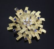 A 1970's? textured 18ct gold, diamond and sapphire set stylised starburst brooch, maker's mark ET,