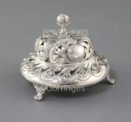 A late Victorian pierced and repousse silver table bell by Samuel Walton Smith, on three paw feet,