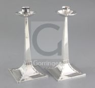 An Edwardian pair of Arts & Crafts silver candlesticks, by James Dixon & Sons, with square