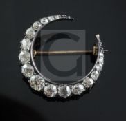 An Edwardian silver, gold and graduated diamond set crescent brooch, 27mm.