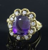 A modern 18ct gold, amethyst and diamond set oval dress ring, size O.
