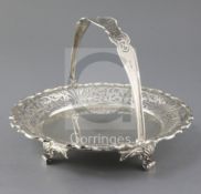 An Edwardian pierced silver fruit basket by Walker & Hall, with pierced handle, on three scroll