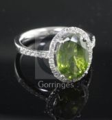 A modern 18ct white gold, green tourmaline and diamond oval cluster ring, with diamond set