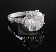 An attractive modern platinum and single stone diamond ring with trapeze cut diamond set shoulders,