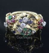 An ornate gold and multi gem set cocktail ring, of foliate design and set with diamonds, emeralds