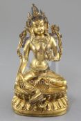 A gilt Tibetan gilt bronze seated figure of Green Tara, 18th century, seated on a double lotus