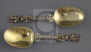 A pair 19th century continental silver gilt spoons with figural terminals, pierced spiral stems