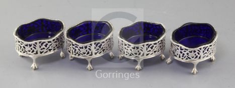 A set of four George III pierced silver oval salts with blue glass liners, by Andrew Fogelberg, on