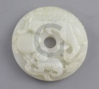 A Chinese pale celadon bi disc, 19th century, carved in high relief with the figure of a lion-dog