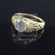 An antique scroll-pierced yellow metal ring set with an oval diamond, tests as high carat,