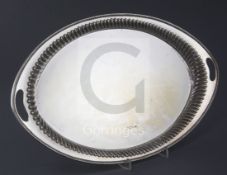 A Victorian silver oval tray by Harrison Brothers and Howson, with inset handles and fluted