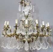 A gilt metal and cut glass fifteen light chandelier, each foliate arm supporting shaped cut glass