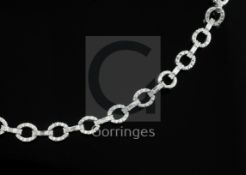 A modern 18ct white gold and round and baguette cut diamond set open work bracelet, approx. 18cm.