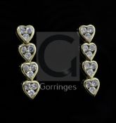 A pair of gold and diamond set drop earrings, modelled as a row of four hearts, each containing