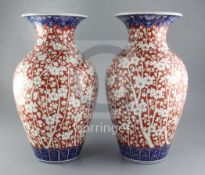 A pair of large Japanese Imari vases, Meiji period each painted with prunus blossom in iron red,