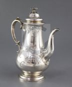 An ornate early Victorian silver coffee pot by The Barnards, with engraved scroll decoration and