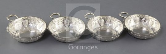A set of four 1970's silver taste vin, by Tessiers Ltd, with vineous decoration and ring handle,