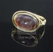 An antique yellow metal and oval carnelian cabochon ring carved with a standing bull, the shank with