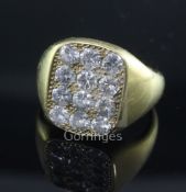 A late 1970's 18ct gold and pave set diamond tablet ring, set with twelve round cut stones, size S/