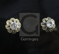 A pair of gold and solitaire diamond ear studs, in a foliate setting.