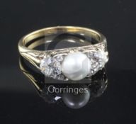 An early 20th century gold, split pearl and diamond set three stone ring, with diamond chip spacers,