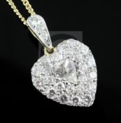 An 18ct gold and diamond encrusted heart shaped pendant with central pear shaped diamond, on an 18ct