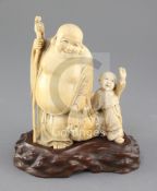 A Japanese ivory okimono of Hotei and a boy, early 20th century, the figure holding his sack of wind