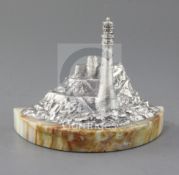 A modern silver miniature model of a lighthouse in a rocky coastline by J.A. Campbell, on a demi-
