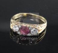 A 9ct gold, ruby and diamond three stone ring, the setting set with four smaller diamonds, size O.