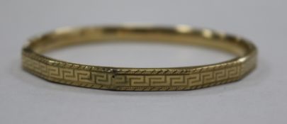 An engraved 9ct gold bangle.