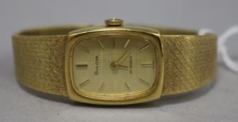 A Bulova ladies' 18ct gold wristwatch with gilt dial and baton numerals on textured tapered flexible