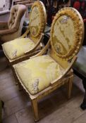 A pair of Italian side chairs upholstered with a yellow fabric printed with feathers, tigers and