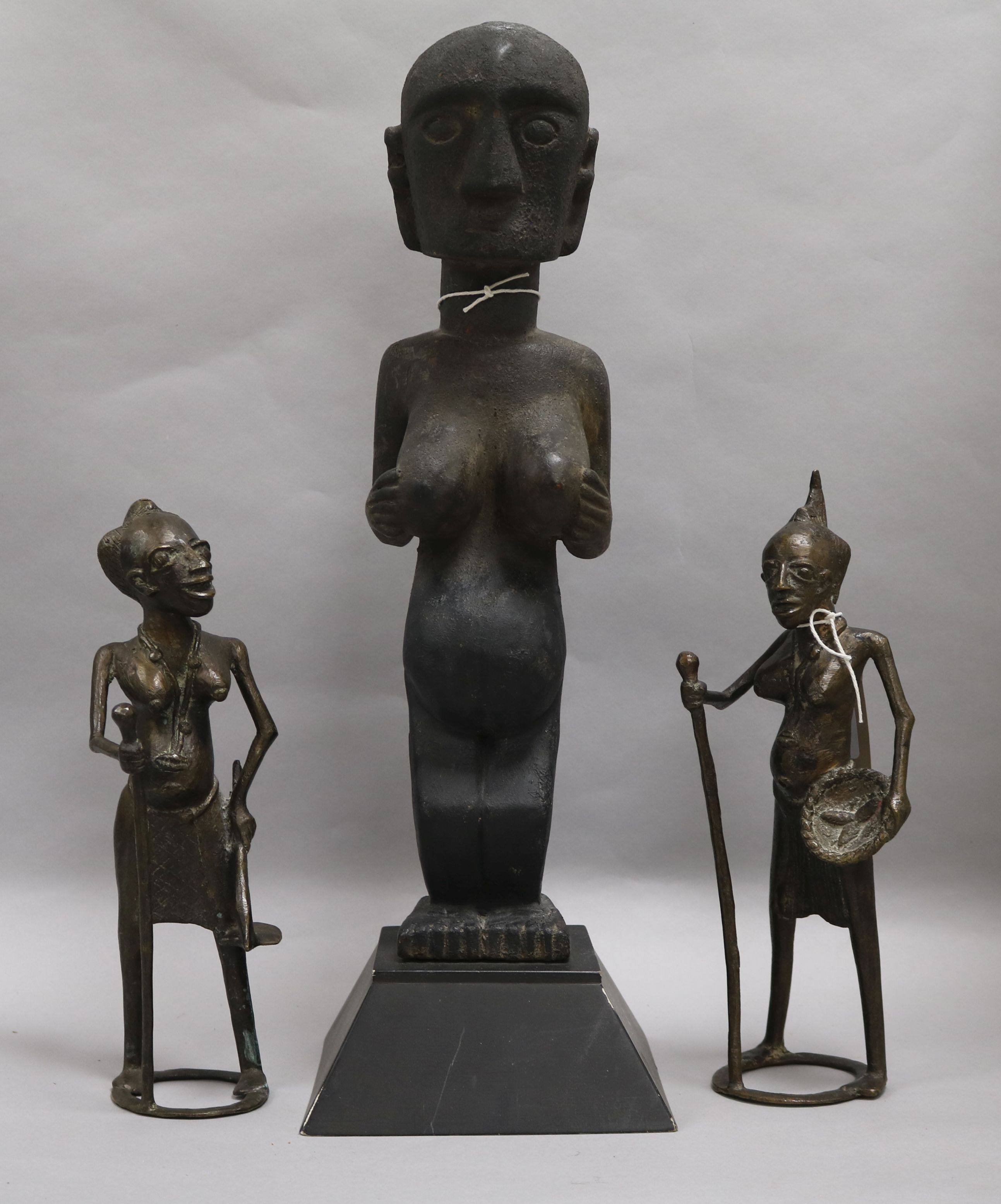 Two African bronze stylised female figures and a carved wood female fertility figure standing on