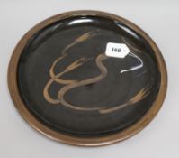 A David Leach Lowerdown Pottery Willow Tree charger, resist-decorated in brown on a dark chocolate