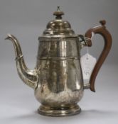 A silver coffee pot, of tapered ovoid reeded and gadrooned form with wooden handle and finial, on