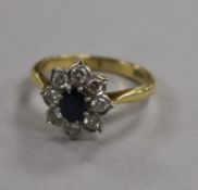 An 18ct gold and platinum, sapphire and diamond cluster flower head ring, size M.