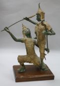 An Indonesian bronze group of two deities fighting, with gilt and green patination, on rectangular