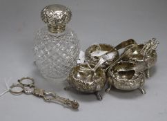 A set of four embossed silver bun salts, a silver-mounted hobnail-cut glass toilet bottle, silver