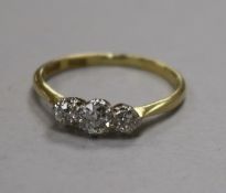 An 18ct gold and platinum three stone diamond ring, size O/P.