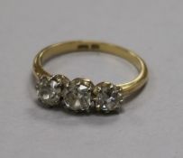 An early 20th century 18ct gold and three stone diamond ring, size M.