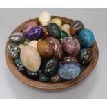 A collection of hardstone eggs in a yew wood bowl