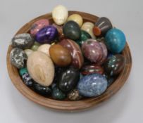 A collection of hardstone eggs in a yew wood bowl