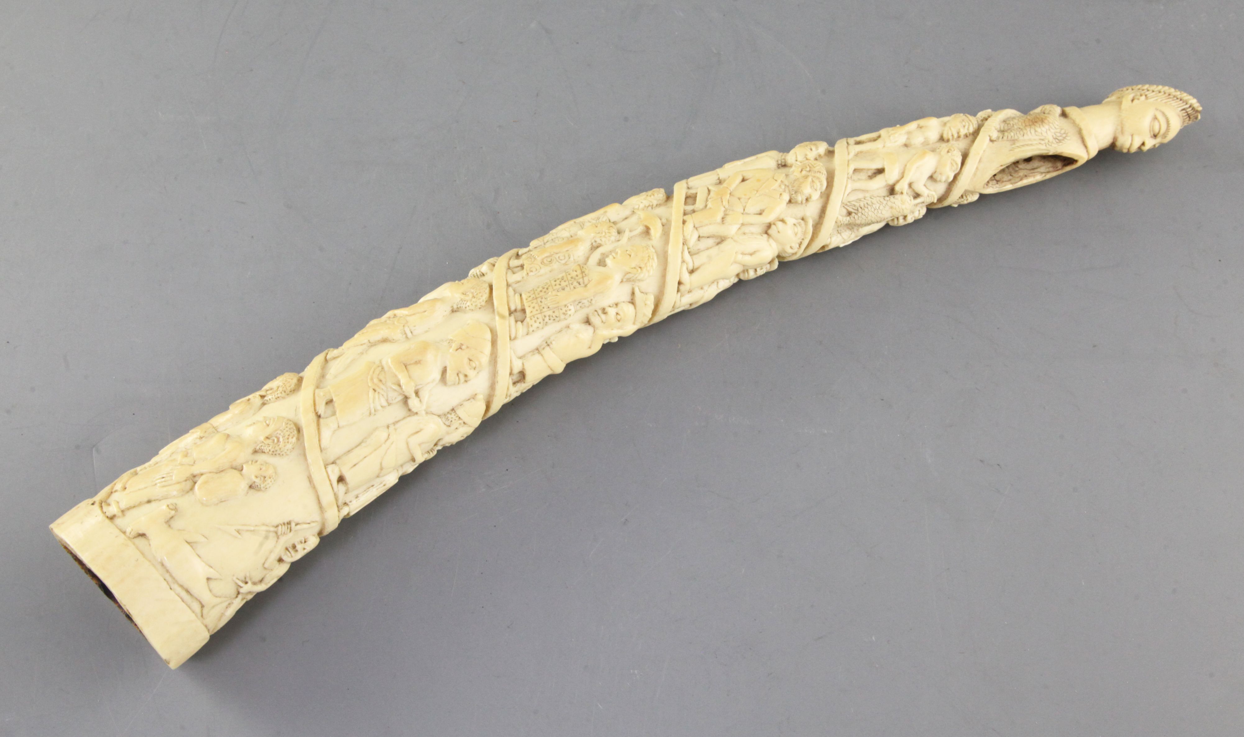 A Belgian Congo ivory oliphant, c.1900, carved with a procession of figures, hammerhead shark