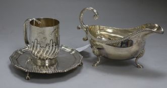 A silver oval gravy boat, a half spiral-reeded silver Christening mug and a circular silver waiter