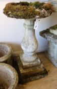 A small reconstituted stone figural birdbath