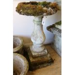 A small reconstituted stone figural birdbath